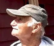A man wearing a hat and looking up.
