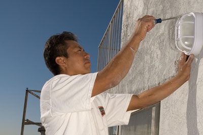 A man painting the side of a building.