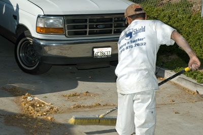 A man in white shirt and hat standing next to a truck.