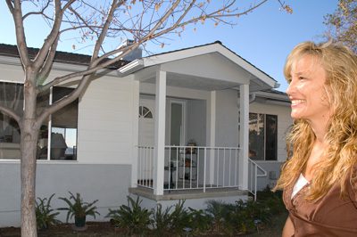 A woman standing in front of a house.