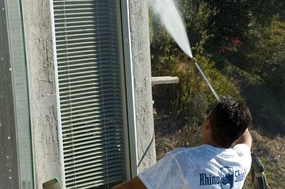 A man is cleaning the outside of a house.
