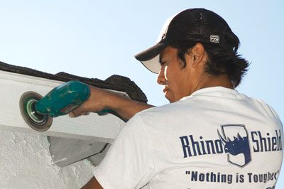 A man in white shirt painting a car.